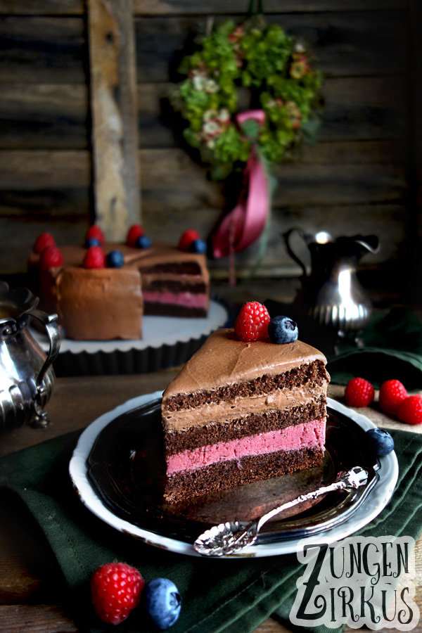 Schokosahnetorte mit rosa Beerencreme und frischen Beeren dekoriert