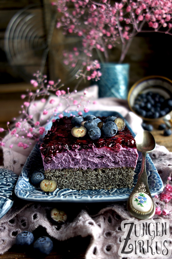 Farbenfroher Heidelbeer-Mohnkuchen auf blauem Teller