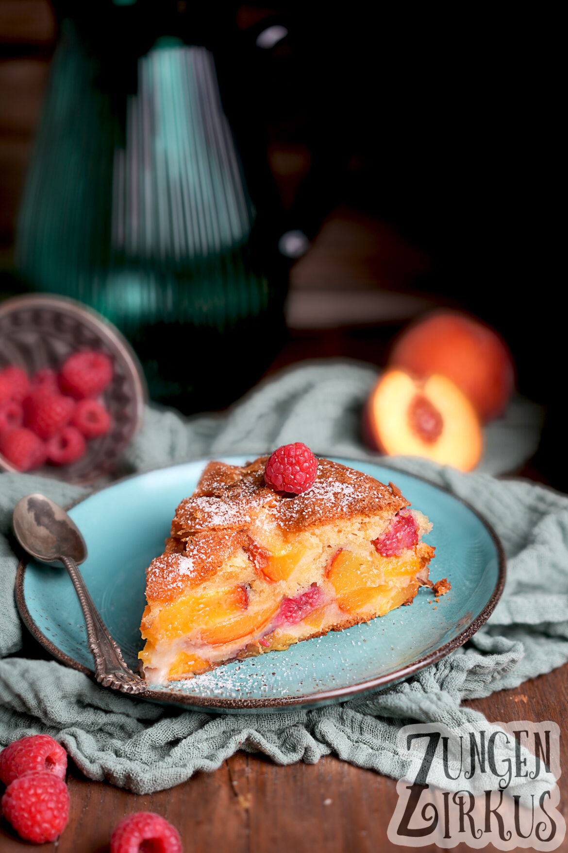 Pfirsich-Melba-Kuchen Ein Stück Rührkuchen mit viel Pfirsichstücke und Himbeeren drinnen.