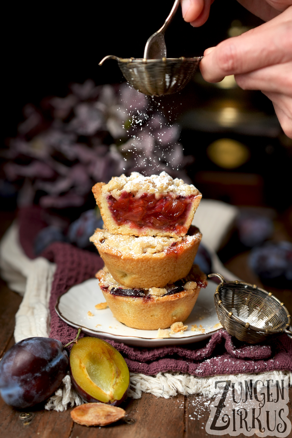 Zwetschgen-Küchlein mit Streusel. In Muffinform gebackene, kleine Mürbeteig-Törtchen. Mit Puderzucker bestaubt.