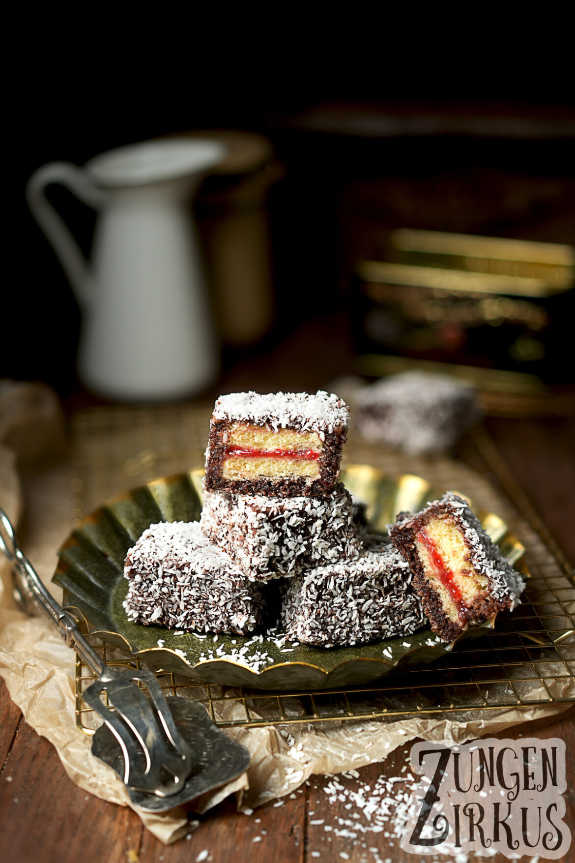 Lamingtons Kuchenwürfel gefüllt mit Konfitüre, in Schokoglasur getaucht und in Kokosflocken gewälzt